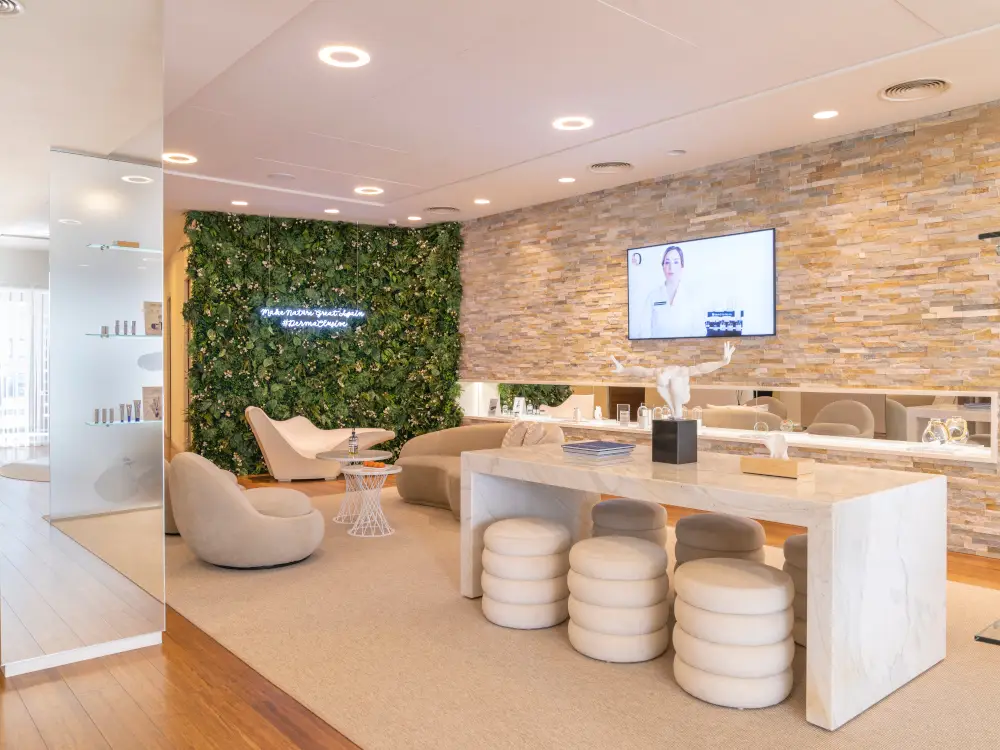 Luxurious spa lounge with modern treatment tables, lush green wall, and elegant decor.