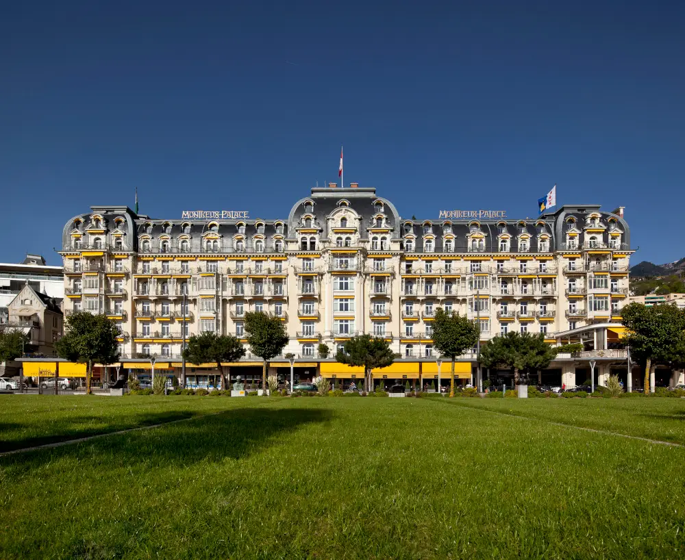 Luxurious hotel facade with elegant architecture against clear blue sky.