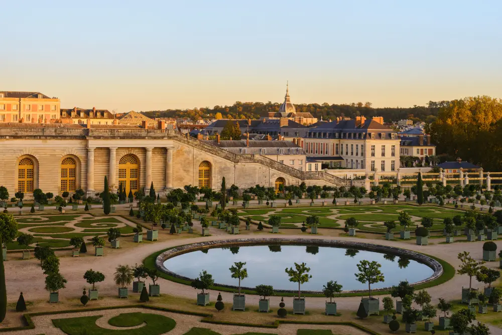 Luxurious garden view with elegant architecture and manicured greenery at sunset.