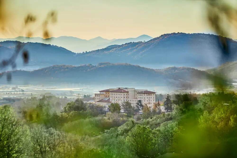 Luxurious spa resort nestled in serene mountains, surrounded by lush greenery.