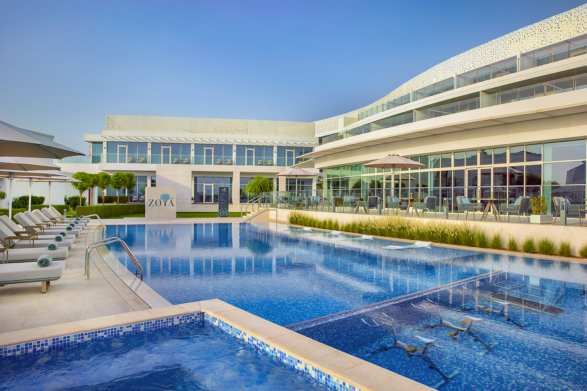 Luxurious spa resort with modern design, featuring premium Gharieni treatment tables by the poolside.