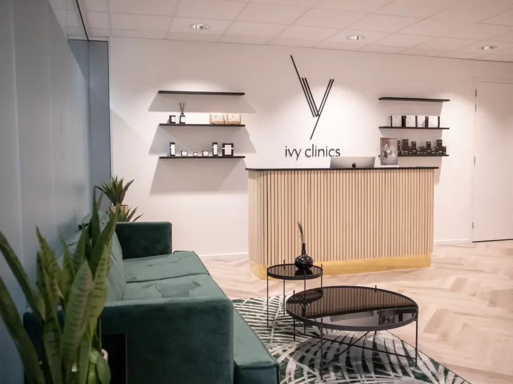 Luxurious spa reception with green sofa, modern decor, and premium treatment products.