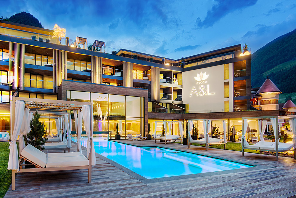 Luxurious spa resort with modern architecture and illuminated pool at dusk.