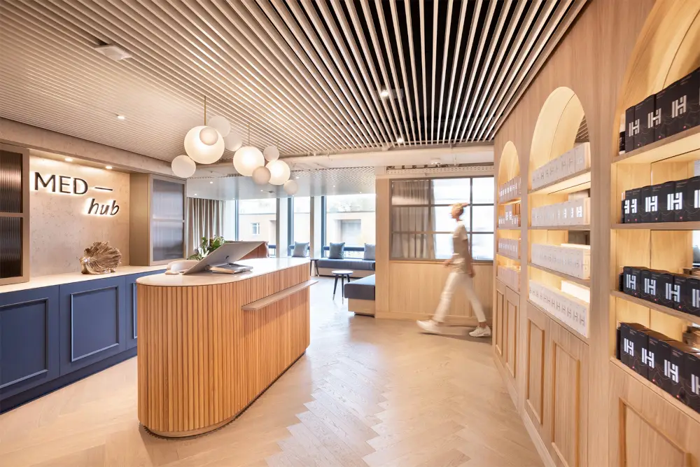 Modern spa reception with wooden accents, sleek design, Gharieni treatment tables, elegant lighting.