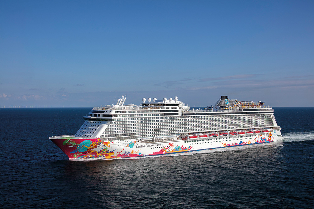 Luxurious cruise ship sailing on open sea under clear blue sky.