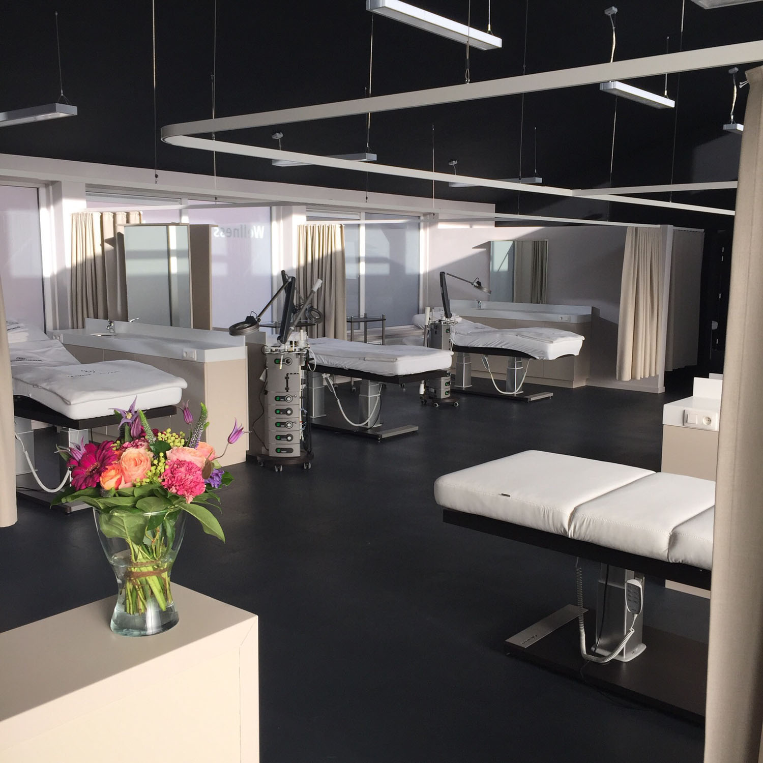 Luxurious spa room with Gharieni treatment tables, modern design, and vibrant floral decor.