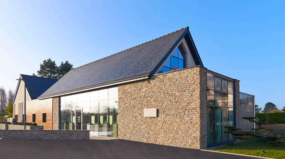 Modern spa facility with stone and glass facade, showcasing luxury wellness architecture.